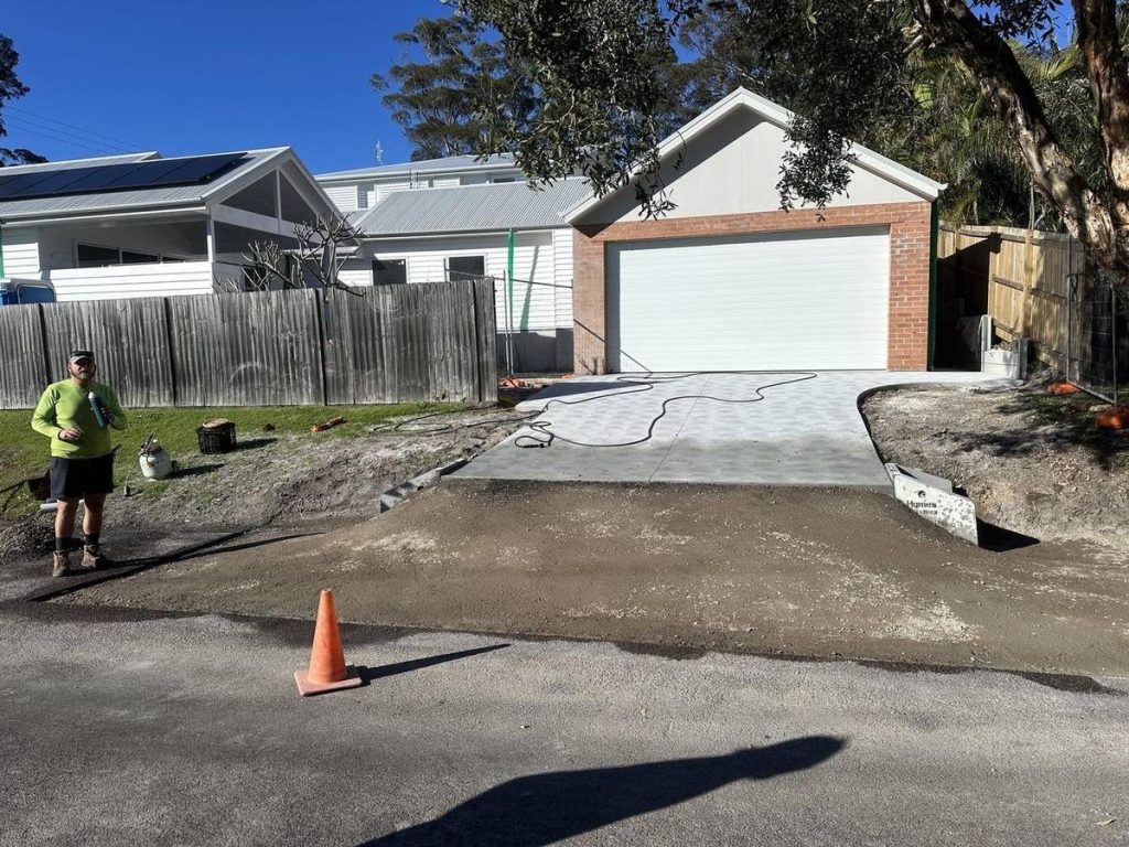 Compacted road base at the boundary, ready for an asphalt crossover
