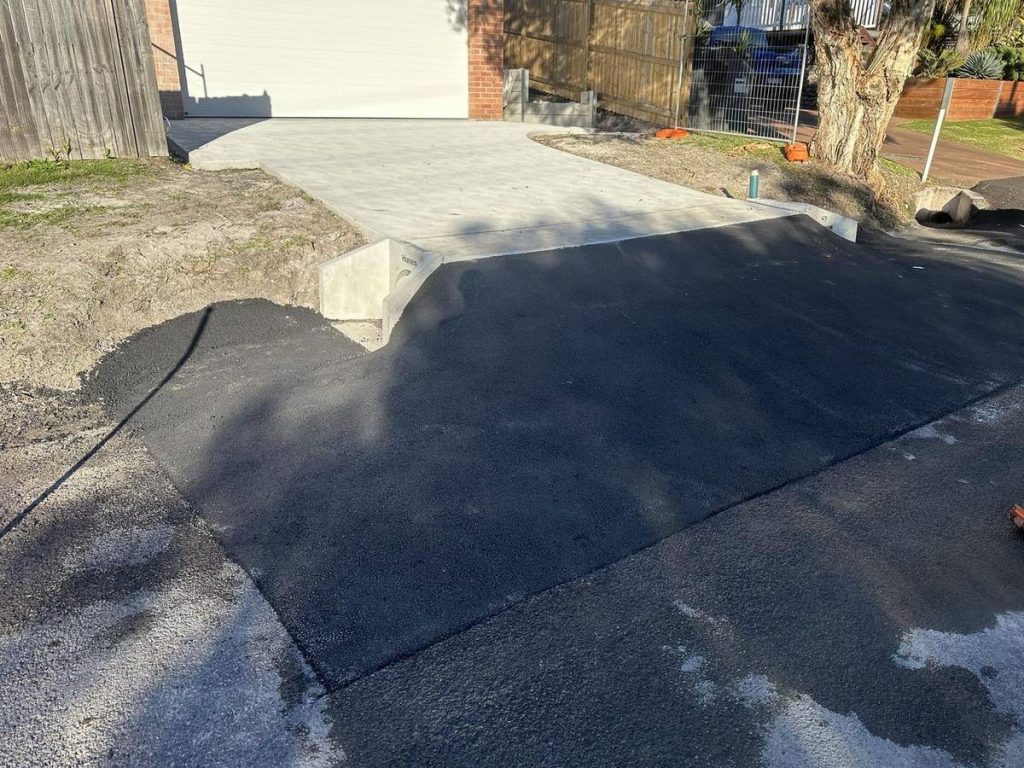 Finished asphalt crossover joining a new concrete driveway
